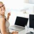 Portrait of smiling young business woman at office desk with laptop